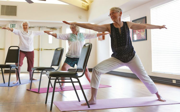 A group of older women performing yoga